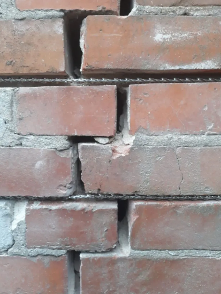 Pęknięcie ceglanego muru biegnące wzdłuż spoin